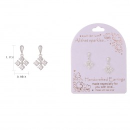 Close-up of a sparkling, white diamond earring set displayed on a purple card with EQ DIAMOND SPKLE SP DNGLY ER 4 branding