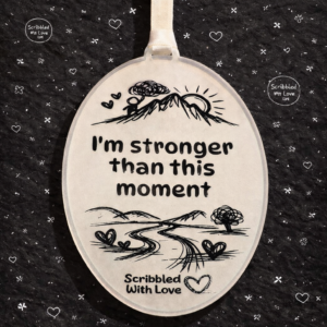 ental health quote plaque reading “I’m stronger than this moment” with hand-drawn mountain and path illustration in black and white Scribbled with Love style.