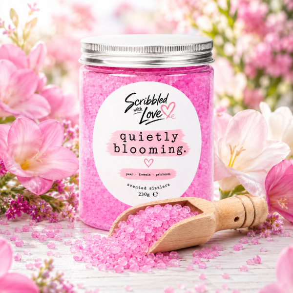 Quietly Blooming Pear, Freesia & Patchouli Scented Sizzlers by Scribbled with Love in a reusable jar with wooden scoop surrounded by pink flowers